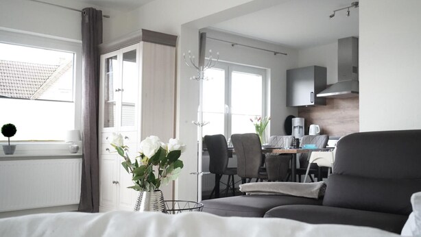 Een moderne hotelkamer met een bed, een eethoek en een kitchenette.