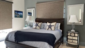 A bedroom with a bed, nightstands, a dresser, and a large mirror. - Welcome to your island home, Mystical Mermaid! (Cruz Bay)