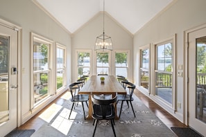 Relax in this spacious room with a large dining table and comfortable seating for six, surrounded by lush views.