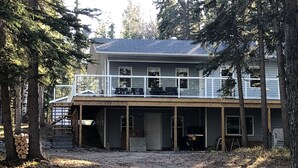 Een huis met twee verdiepingen, een overdekte veranda en een terras.