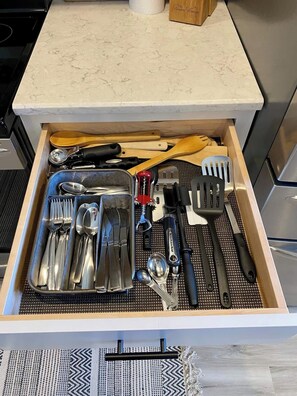 Un tiroir de cuisine contenant des ustensiles et des ustensiles de cuisine.