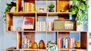 Una estantería de madera con diversos objetos decorativos, libros y plantas.