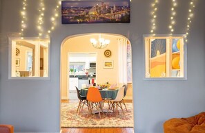 Enjoy meals with family and friends in this stylish dining area, featuring a table set for four and a chandelier.