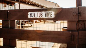 Um portão de madeira com uma placa que diz 'HOT TUB TIME'.