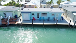 A waterfront property with a dock, a covered deck, and a small building with a porch. - Oceanside waterfront 2/2 home with 55ft dock and paddle equipment (Marathon)
