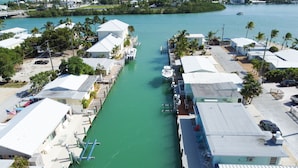 A marina with docked boats, a clear waterway, and buildings with white roofs. - Oceanside waterfront 2/2 home with 55ft dock and paddle equipment (Marathon)