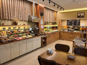 A breakfast buffet with various food options and a seating area.