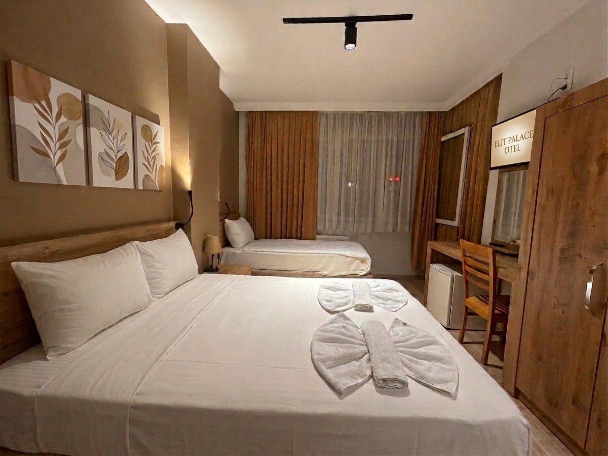 Une chambre d’hôtel avec deux lits, une télévision, un bureau et une armoire.
