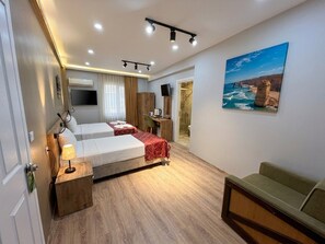A hotel room with a bed, a desk, a chair, a TV, and a painting on the wall. - Elit Palace (Bolu)