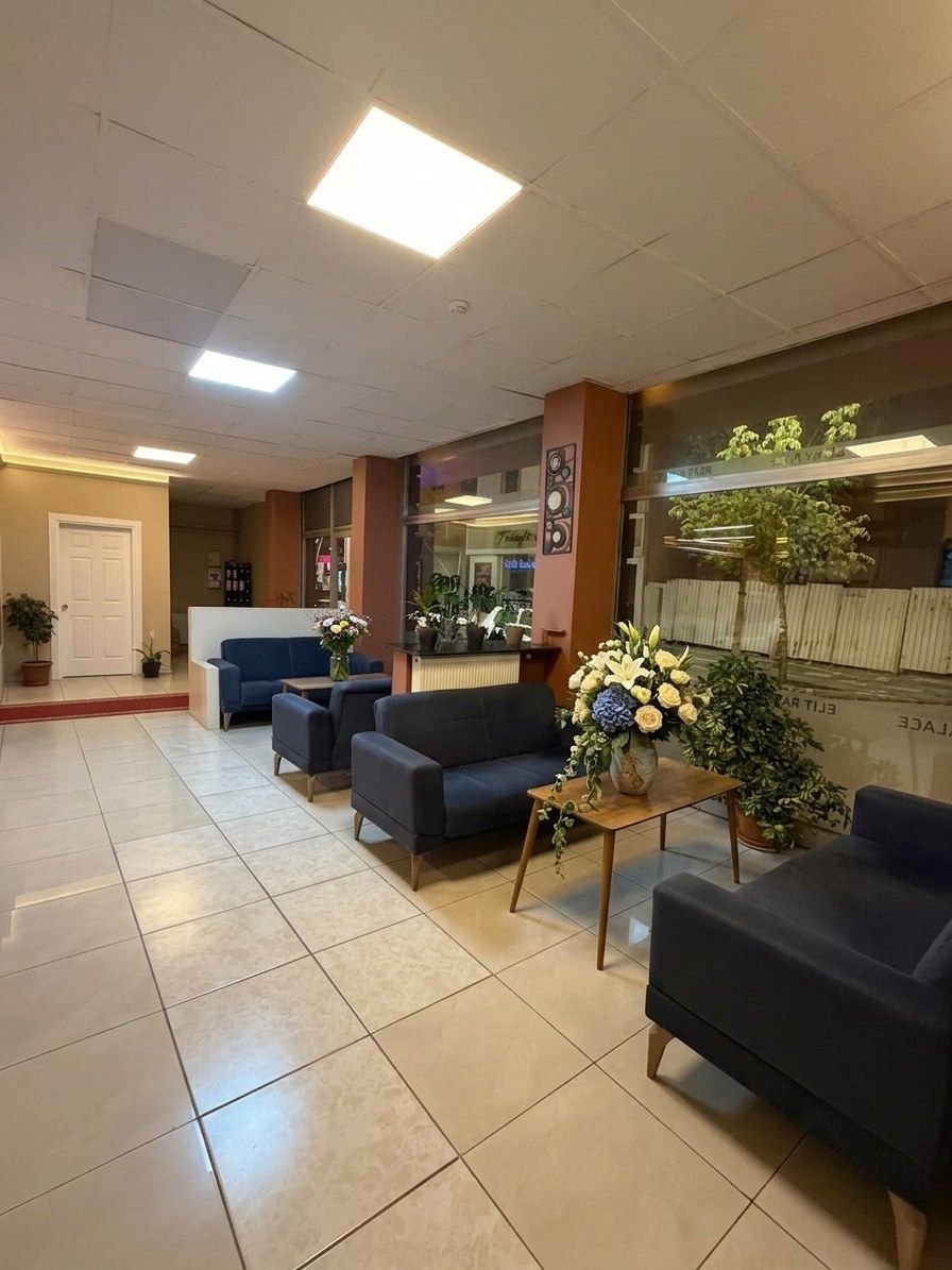 Vestíbulo de hotel con recepción, zona de estar con sofás y un amplio ventanal con vistas.