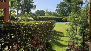 Un espacio al aire libre cubierto con césped, palmeras y macizos de flores.