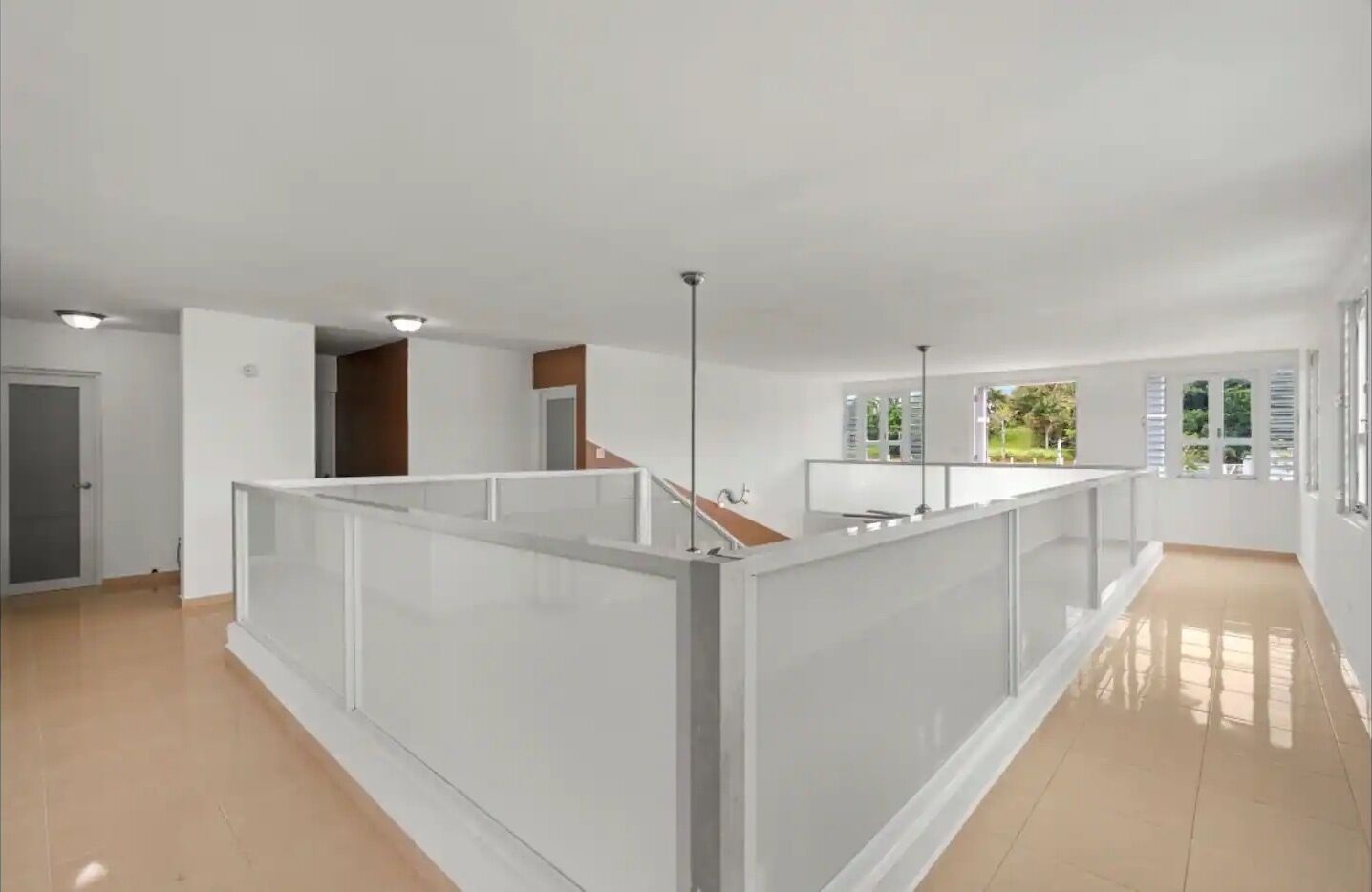A spacious, modern apartment with a balcony, large windows, and a clean, minimalist design.