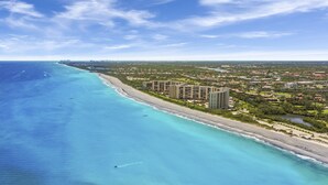 A coastal resort with beachfront villas, a sandy beach, and a clear view of the ocean.