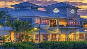 A multi-story hotel with a modern architectural design, featuring a prominent logo on the facade.