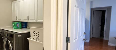 A laundry area with a washing machine, a dryer, and a cabinet.