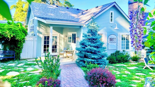A bungalow with a porch, a small tree, and a sign that reads "BRITT BUNGALOW." - Spa Like Stay at the Award Winning Britt Bungalow in the Heart of Jacksonville (Jacksonville)