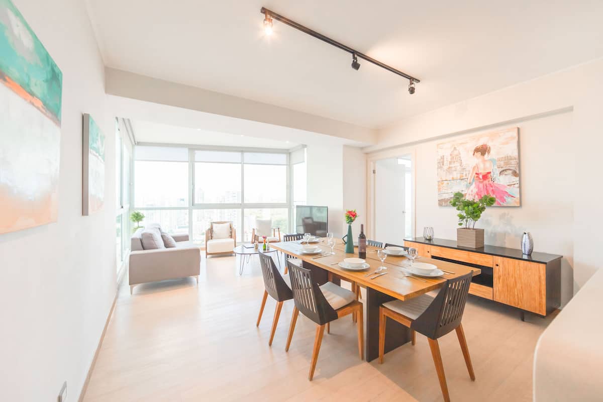 Ein moderner Essbereich mit einem Holztisch, schwarzen Stühlen und einem minimalistischen Design.