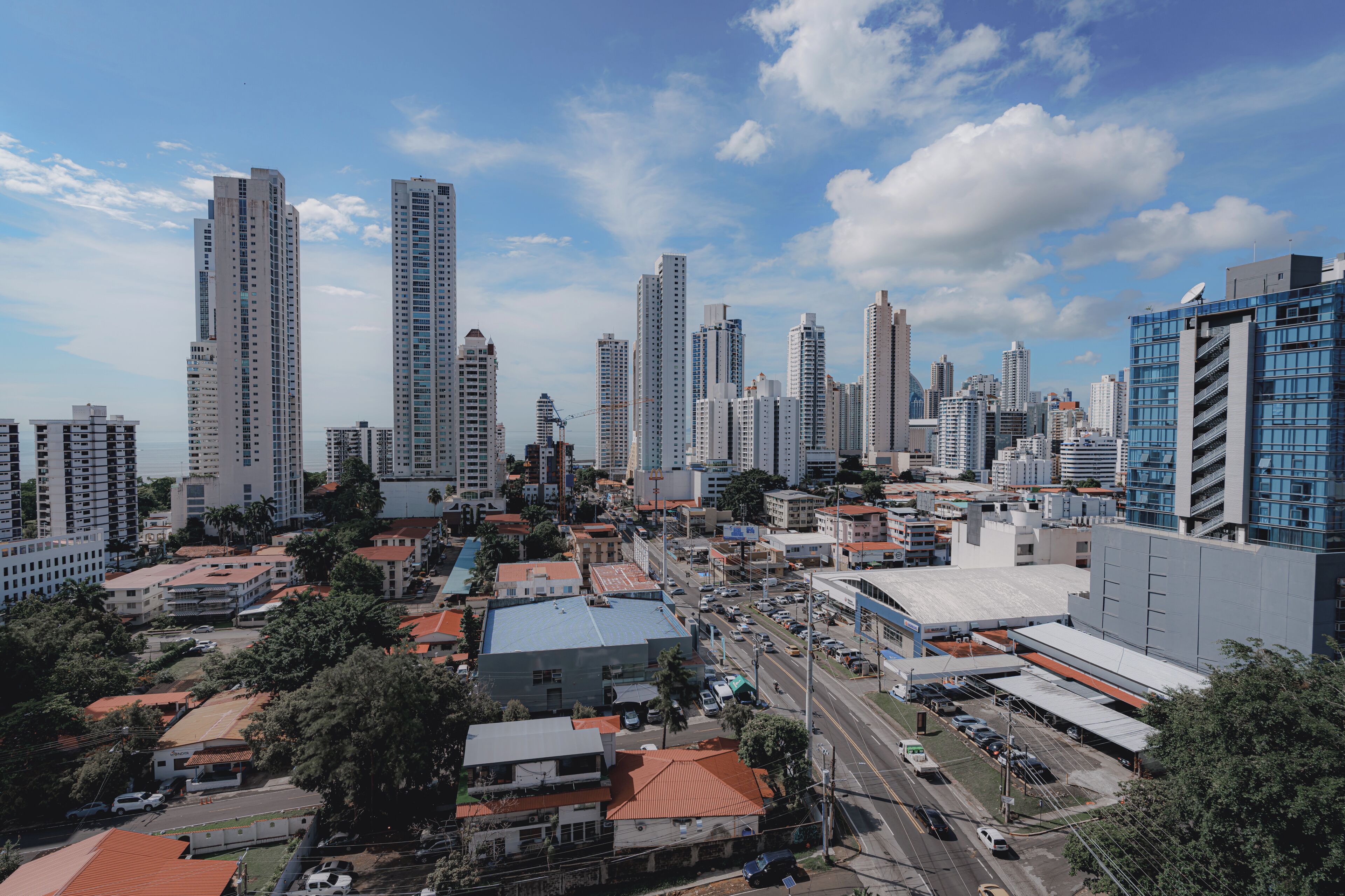 A cityscape with high-rise buildings, a mix of residential and commercial structures, and a clear sky.