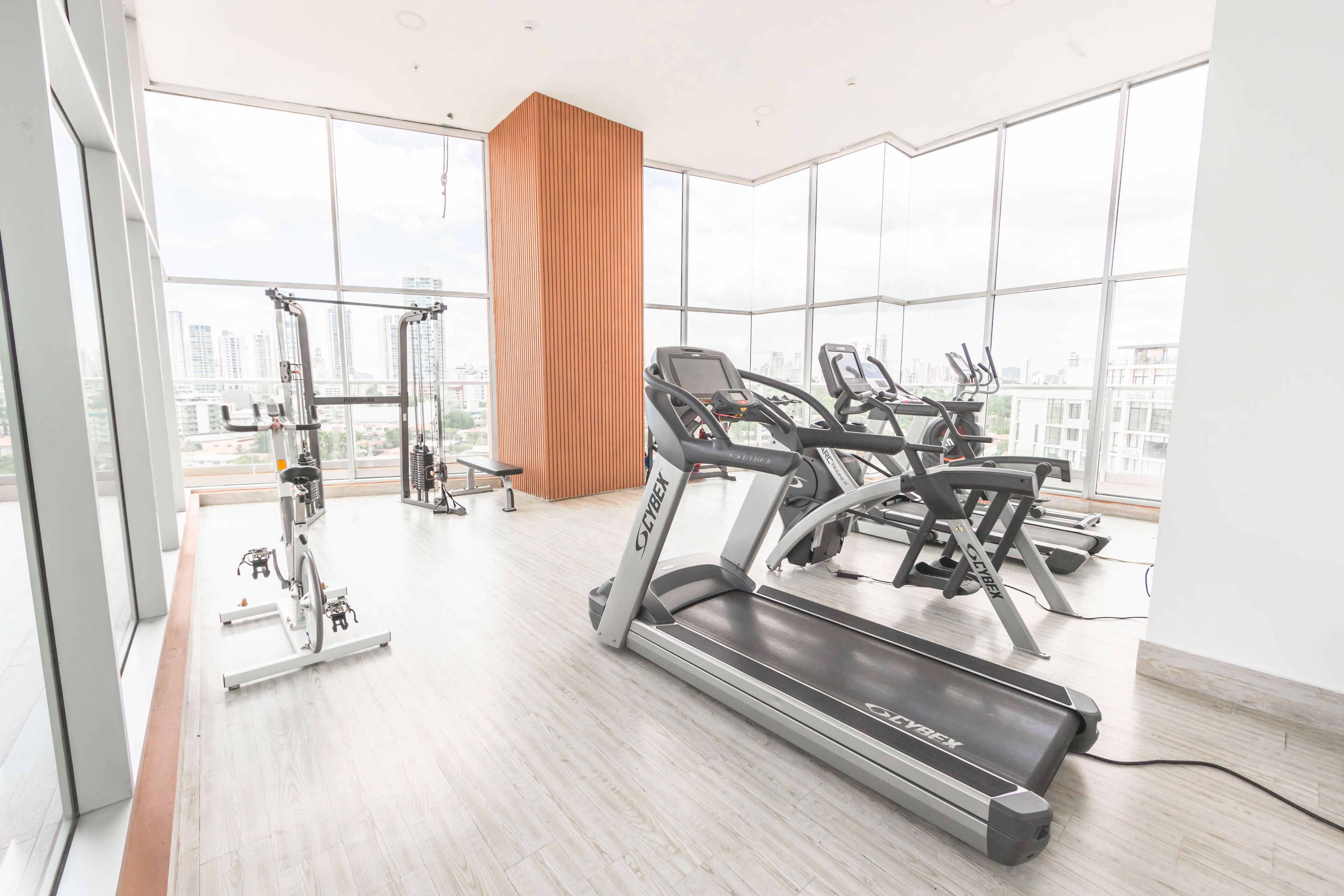 Ein modernes Fitnessstudio mit Laufbändern, einem Ergometer und einem Krafttrainingsgerät.