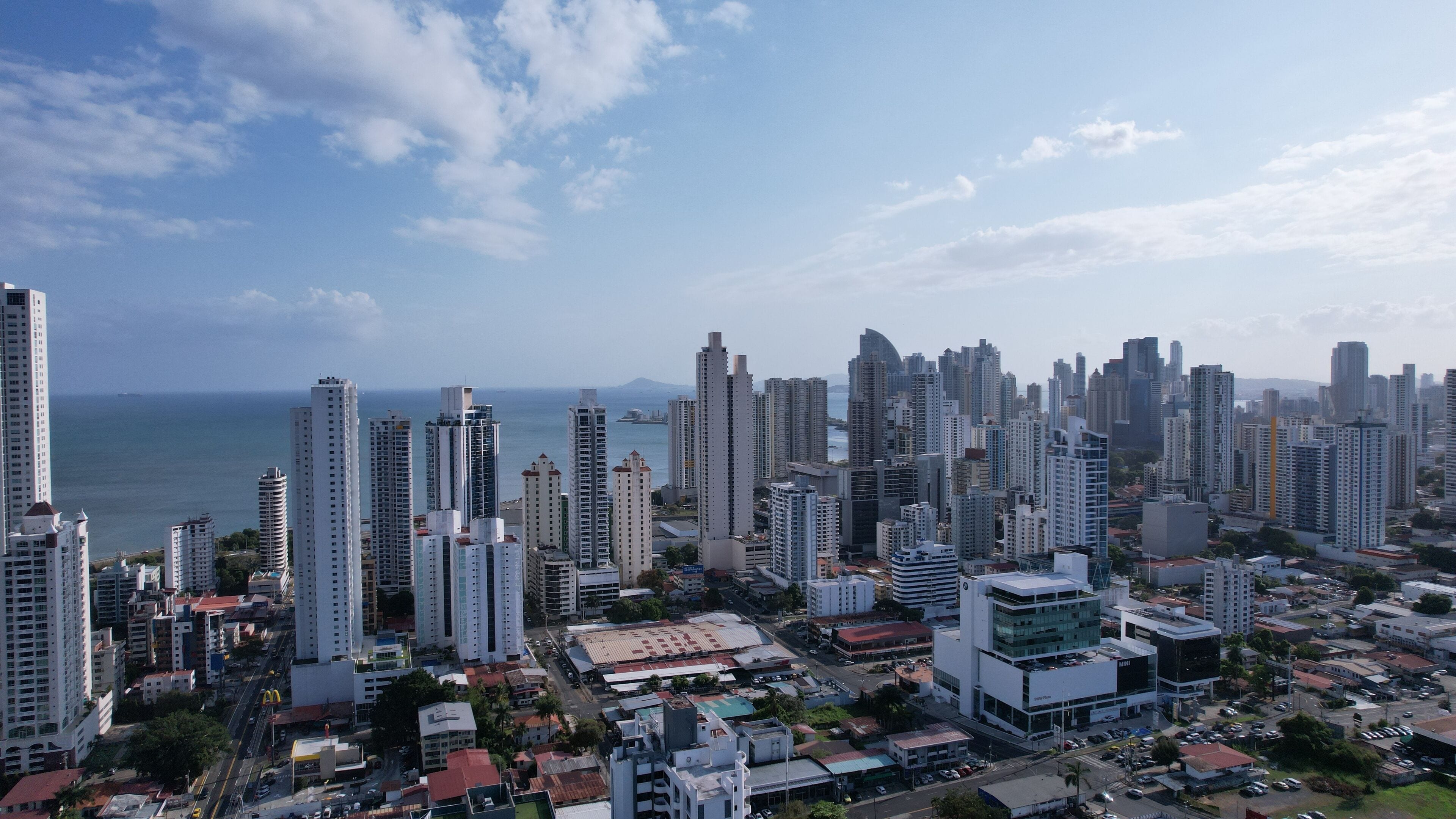 A cityscape with high-rise buildings, a marina, and a clear sky.