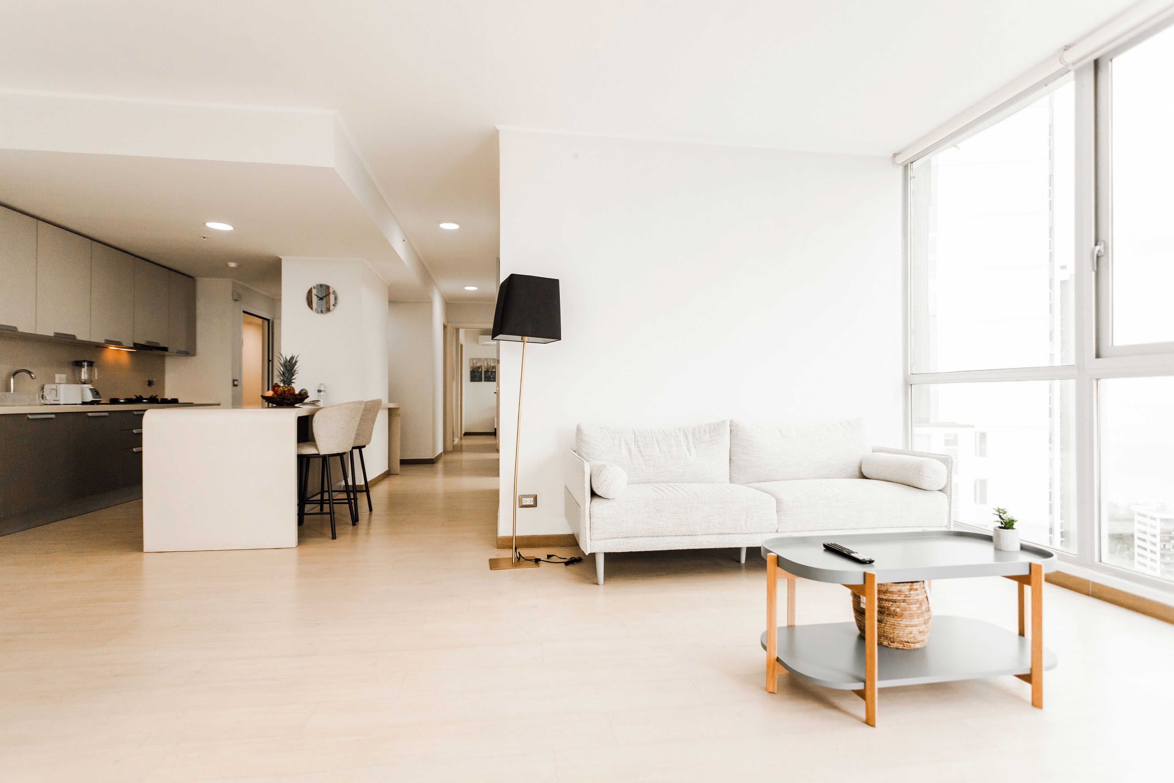 A modern living space with a kitchen, dining area, and a large window providing natural light.