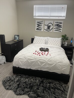 Cozy retreat with a large bed, two nightstands, and a window with blinds.