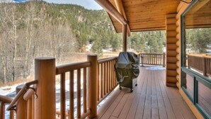 A wooden deck with a view of a forested mountain. - Beautiful Log Cabin with Acreage (Estes Park)