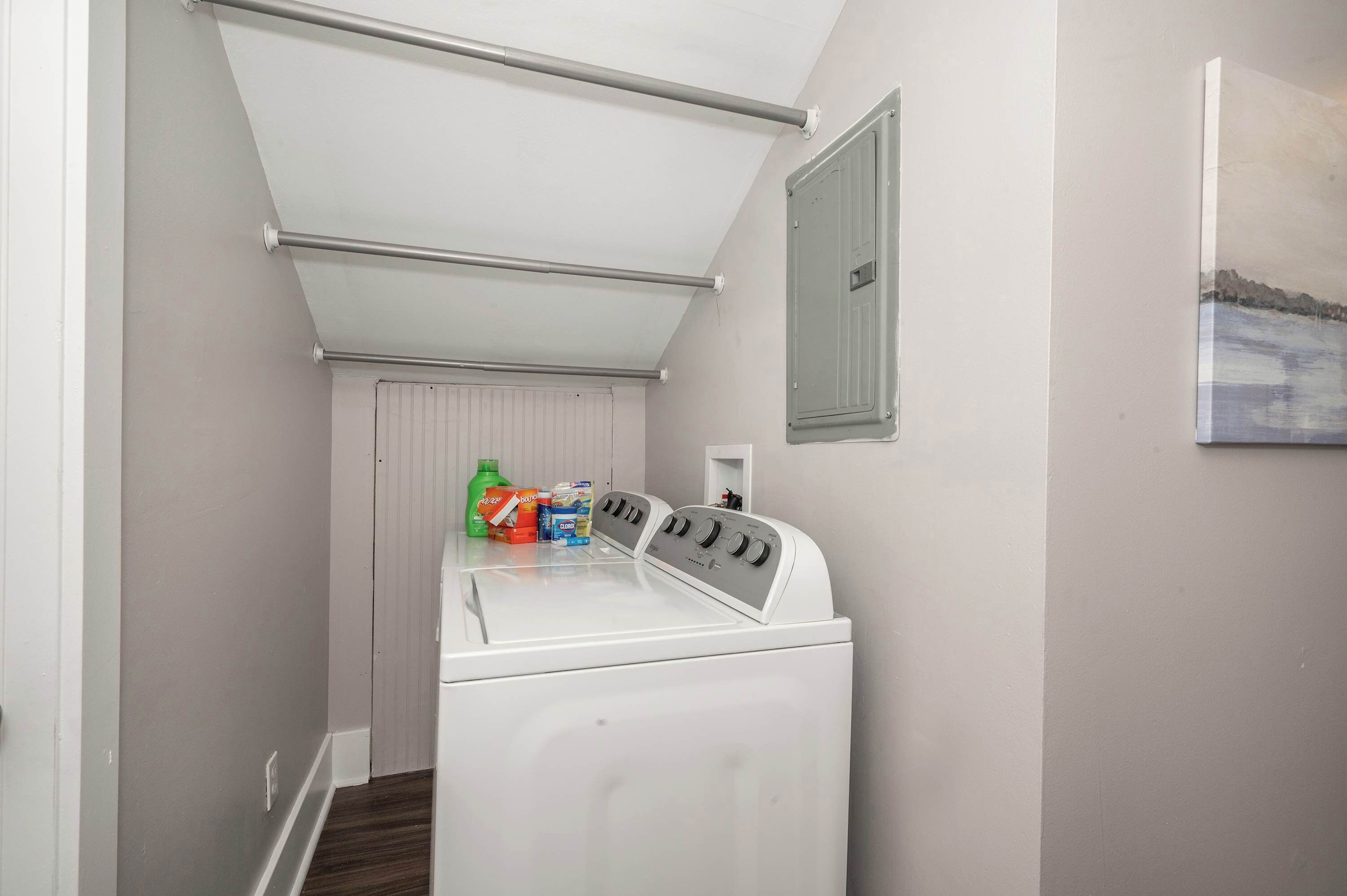 Une buanderie équipée d’un lave-linge et d’un sèche-linge à chargement frontal, d’un porte-serviettes et d’un radiateur.