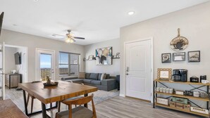 A modern living room with a wooden dining table, a gray sofa, and a coffee station. - A Little Slice of Branson - Ozarks Views (Branson)