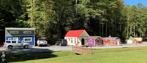 A campground with RVs, a large blue building, and several colorful cabins.