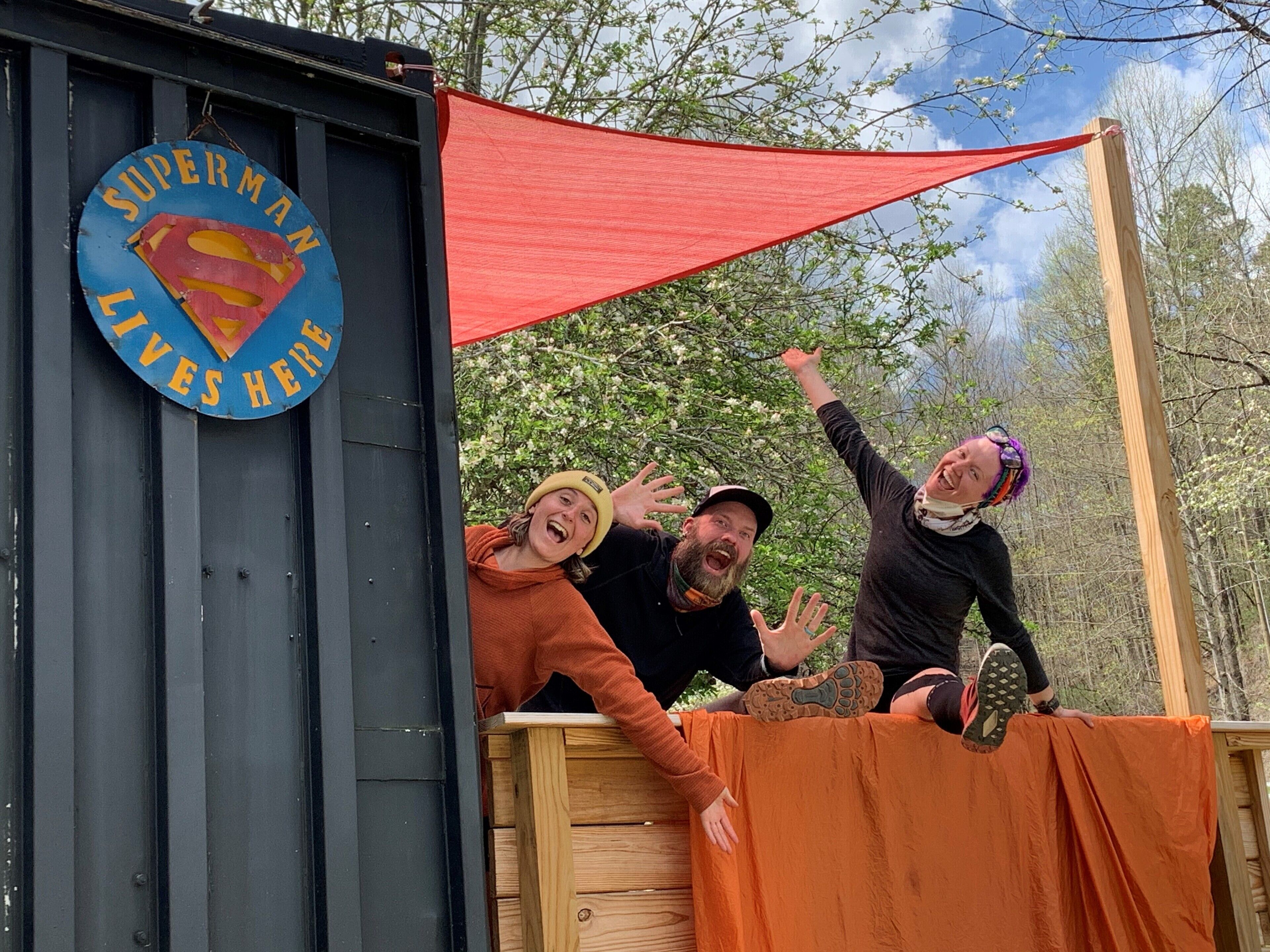 A wooden structure with a Superman sign and a red tarp.