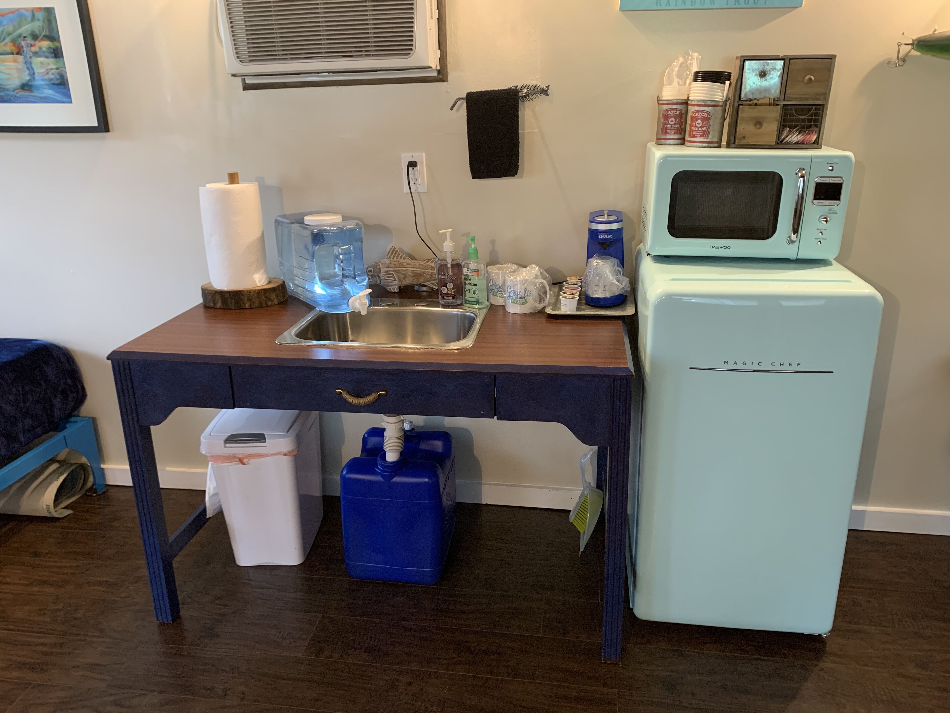 A compact kitchen with a sink, a microwave, and a refrigerator.