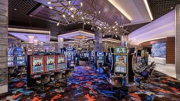 A casino with slot machines, gaming tables, and a patterned carpet.