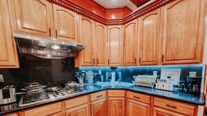 Una cocina con armarios de madera, estufa de acero inoxidable y encimera azul.