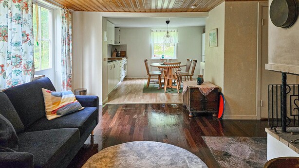 A cozy living room with a sofa and a dining area with a table and chairs. - Beautiful home in älmhult with kitchen (Älmhult)