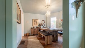 Una cocina rústica con mostradores de madera, un candelabro y un ventanal amplio.
