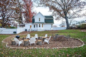 A white house with a green roof, surrounded by a wooden deck with Adirondack chairs and a table. - Relaxing Farmhouse, pet friendly, walk to town (Burnsville)
