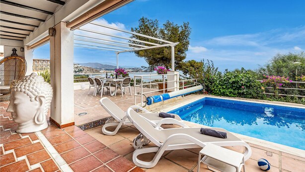 Un espace aménagé au bord de la piscine, comprenant une pergola, des chaises longues et une table à manger avec des chaises.