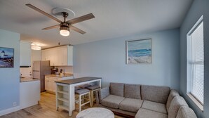 A modern living room with a gray sofa, a small round table, and a ceiling fan. - Discover Micco charm, just a quick 23-min drive to Wabasso Beach Park (Micco)