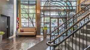 A modern lobby with a staircase, a sofa, and a potted plant. - Your Home Base in the Heart of Seattle (Seattle)