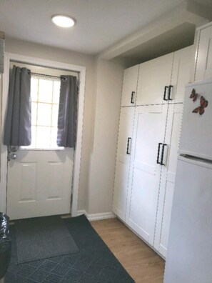 Kitchen area with a refrigerator, cabinets, and window.