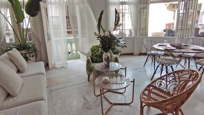 A spacious living area with a white sofa, a round table, and wicker chairs. - Gorgeous Republican. Apt inside old city. (cartagena)