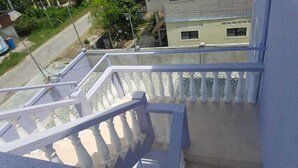 Een witte trap met balustrades die uitkomt op een plateau.