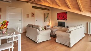 Un espacio habitable amplio con un techo alto de madera, una mesa de comedor con sillas y dos sofás.