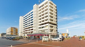 A multi-story hotel with a central courtyard, a flag on top, and a visible sign for 'Hotel Rot'.