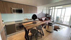 Una cocina moderna con una isla central, electrodomésticos de acero inoxidable y un comedor con taburetes.
