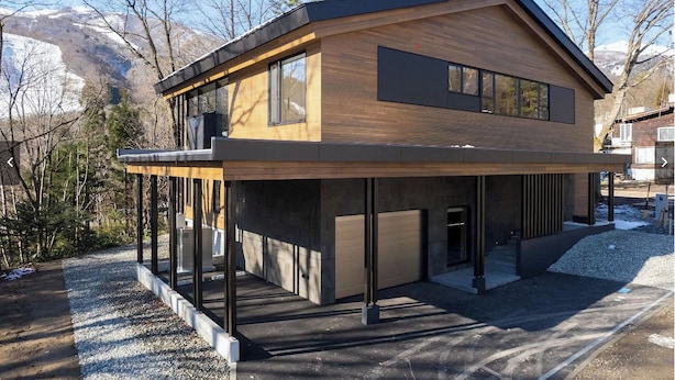 A modern two-story house with a wooden facade, large windows, and a covered outdoor area. - Zenrinso (Hakuba)