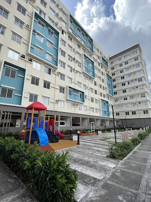 Stylish residential building with a play area and landscaped grounds.