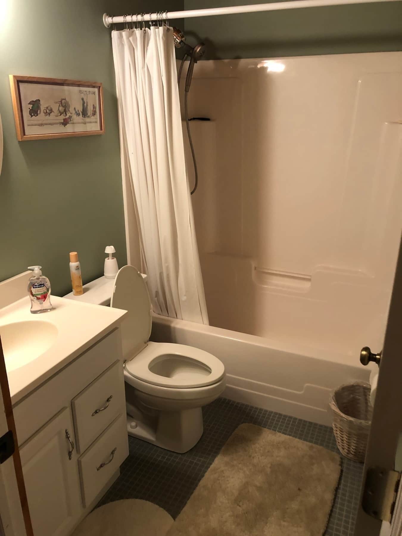 A bathroom with a toilet, sink, and shower area.
