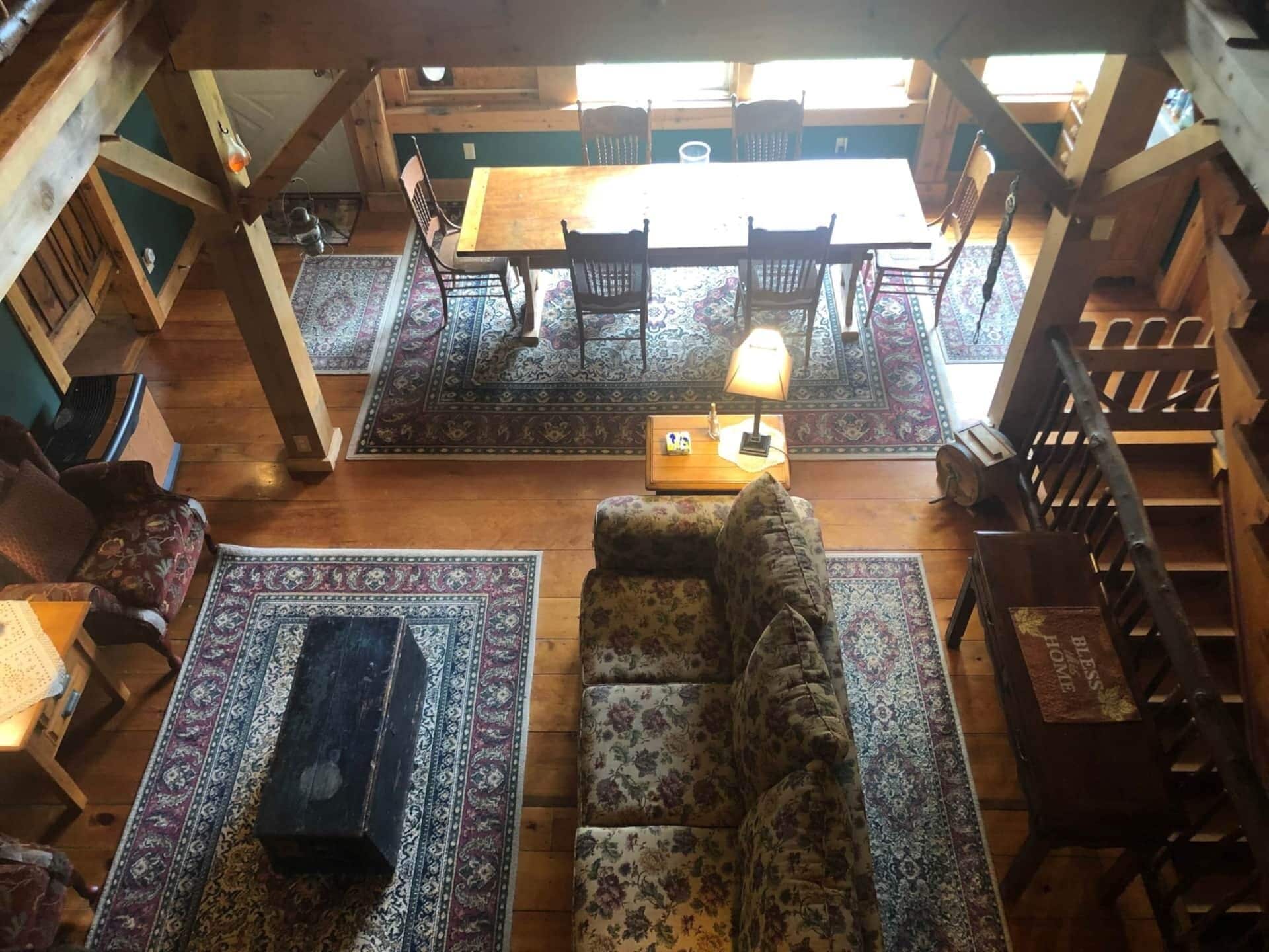 Un intérieur chaleureux et rustique, avec une table et des chaises en bois, un canapé et des tapis à motifs.